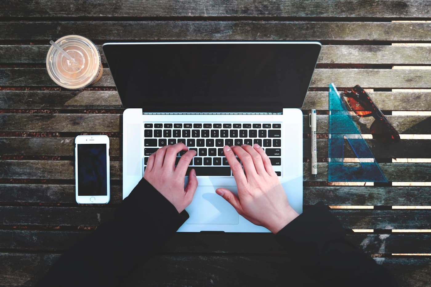 Flat-lay of a laptop, phone and coffee on a creative's desk